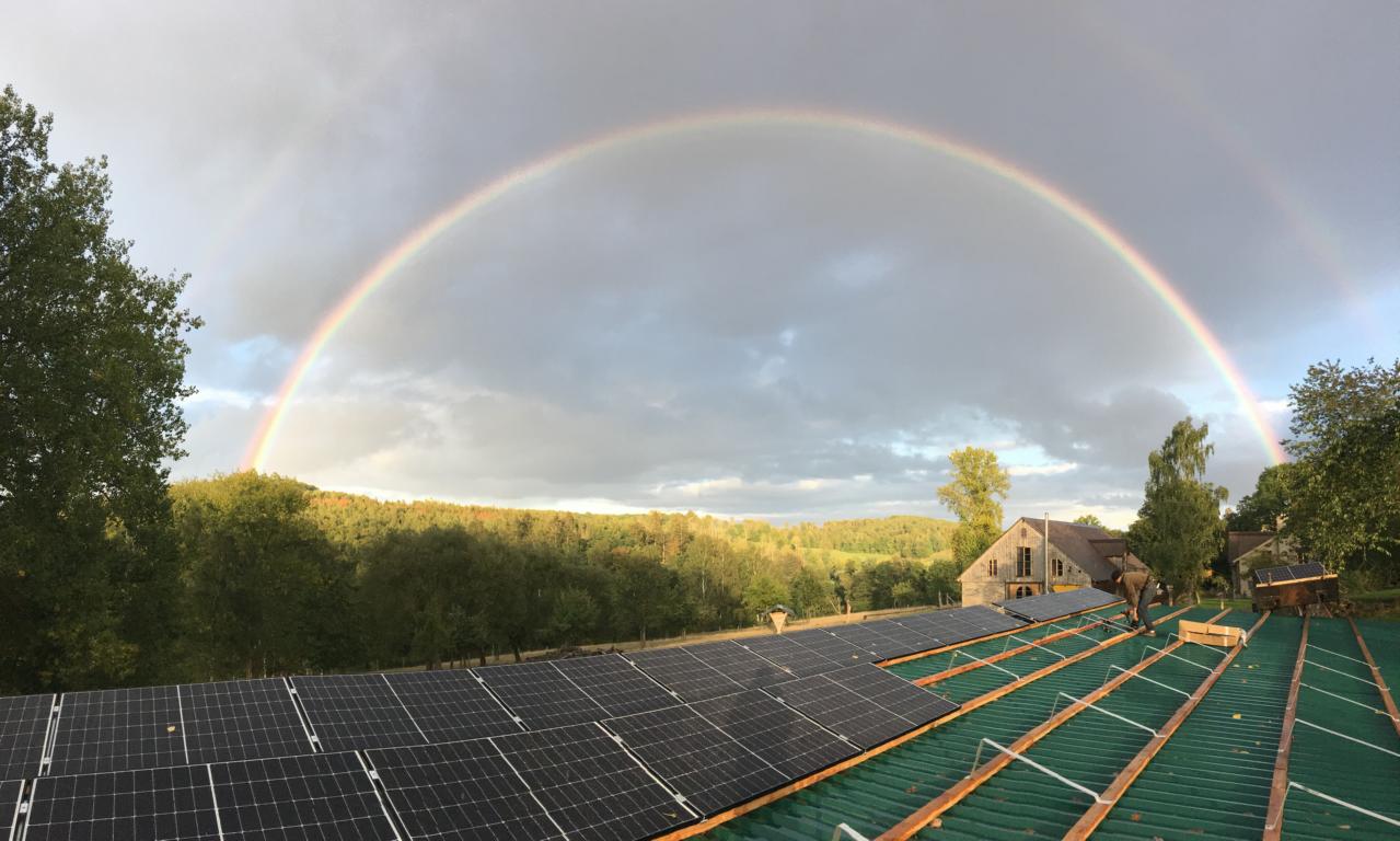 Regenbogen über einer Solaranlage auf einem Flachdach im Harz