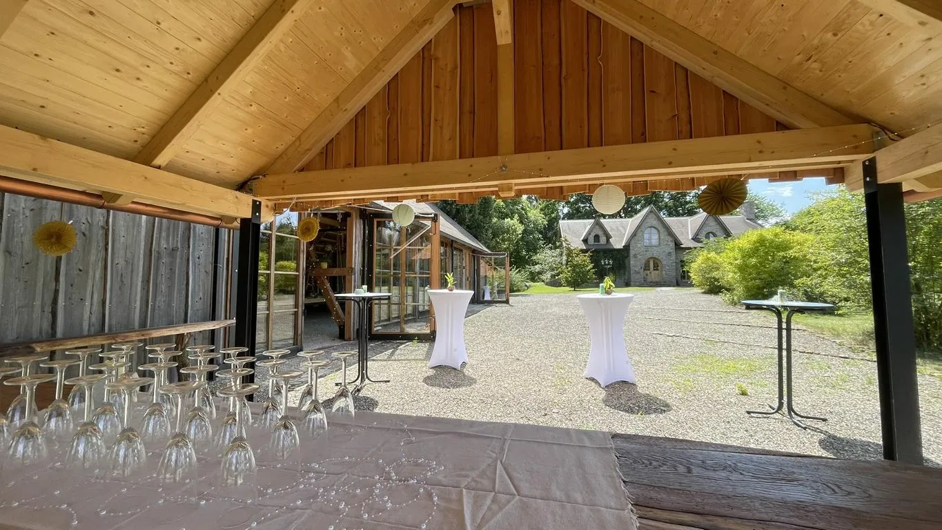 Sektempfang mit Stehtischen und weißen Hussen - Scheunen-Hochzeit im Highland-Stil im Harz in Earl's Lane