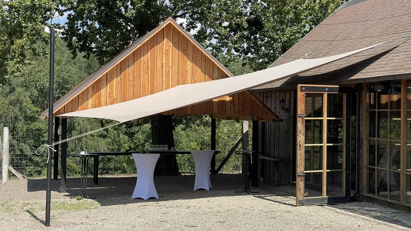 Sonnensegel und Regenschutz vor Ausgang Scheunen Location mit Stehtischen und weißen Hussen - Vermietung für Scheunen-Hochzeit im Harz in Earl's Lane